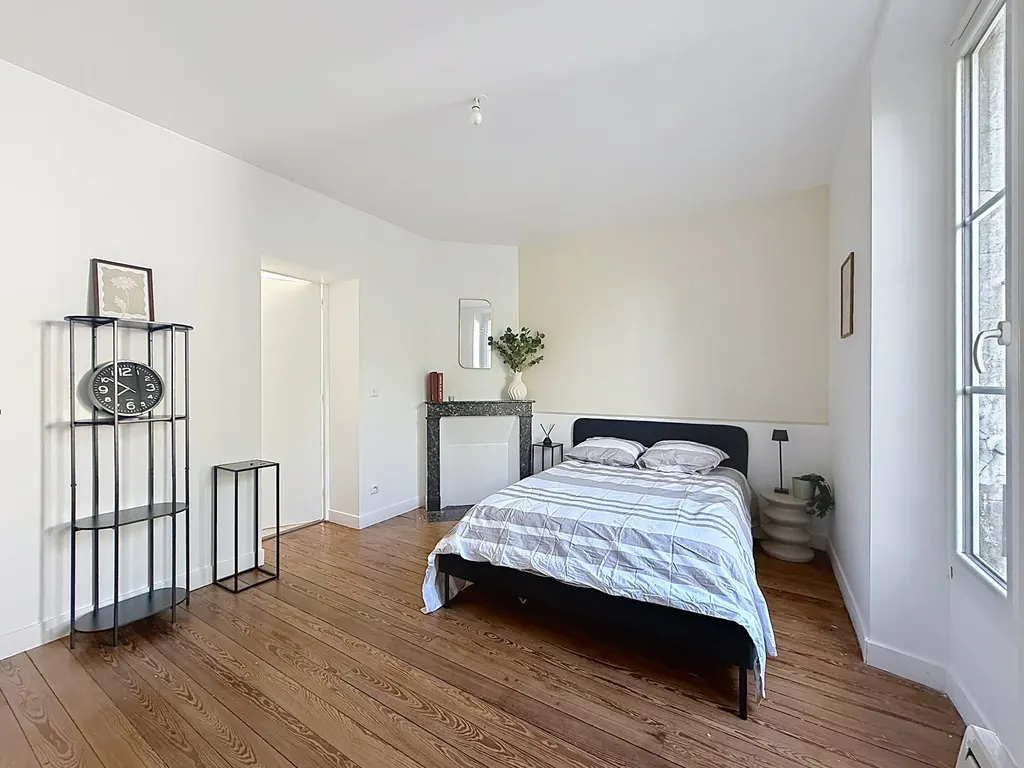 Chambre avec parquet, cheminée en marbre et fenêtre sur la verdure