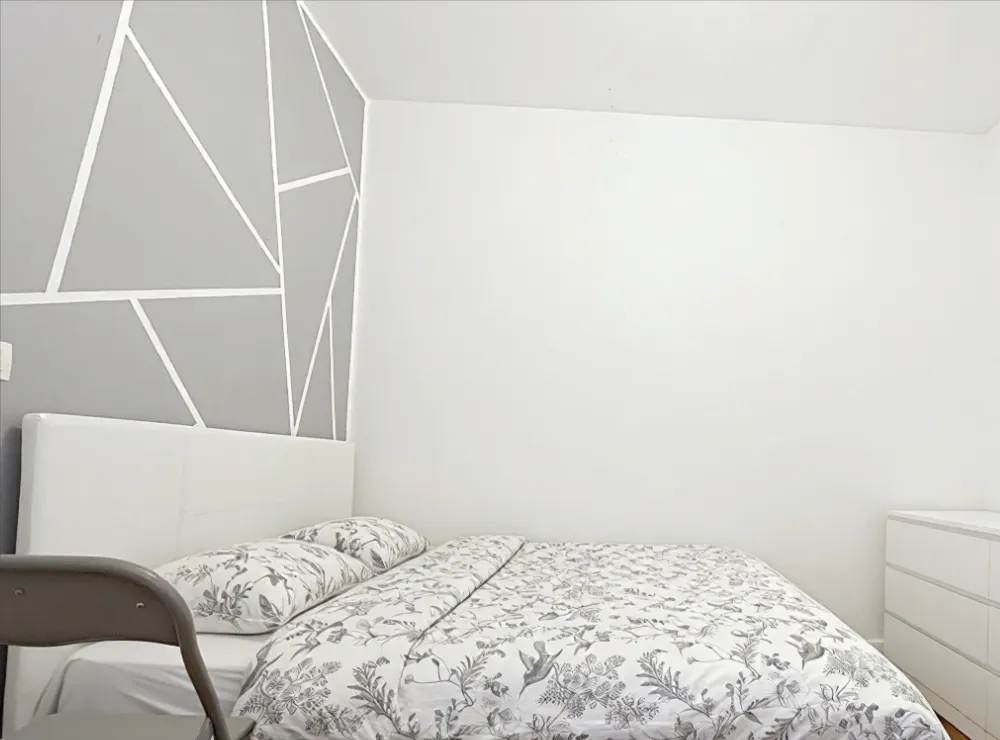 Chambre sous pente avec parquet et tête de lit blanche
