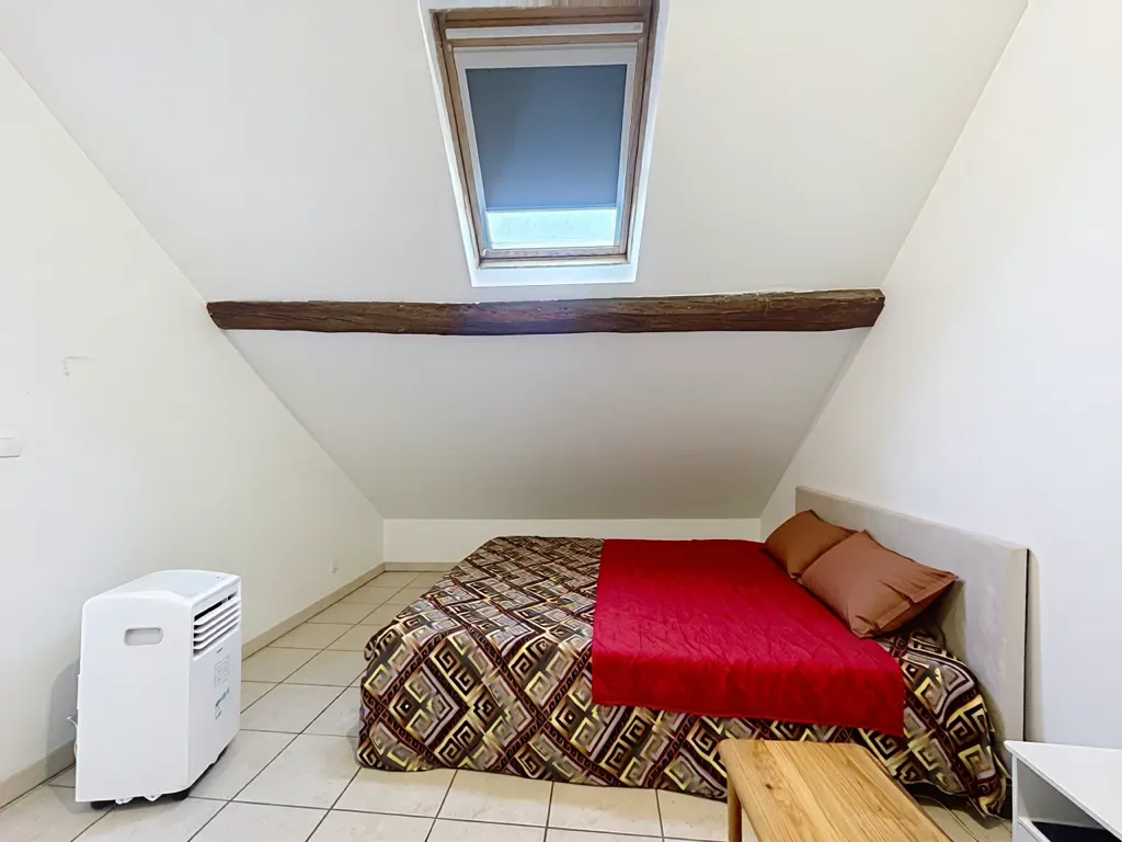 Chambre mansardée avec fenêtre de toit dans l'un des logements loués