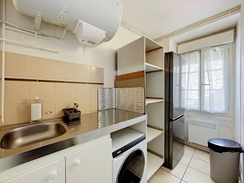 Cuisine avec plan de travail inox et fenêtre sur rue