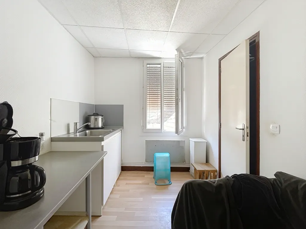 Kitchenette avec évier inox et fenêtre à store