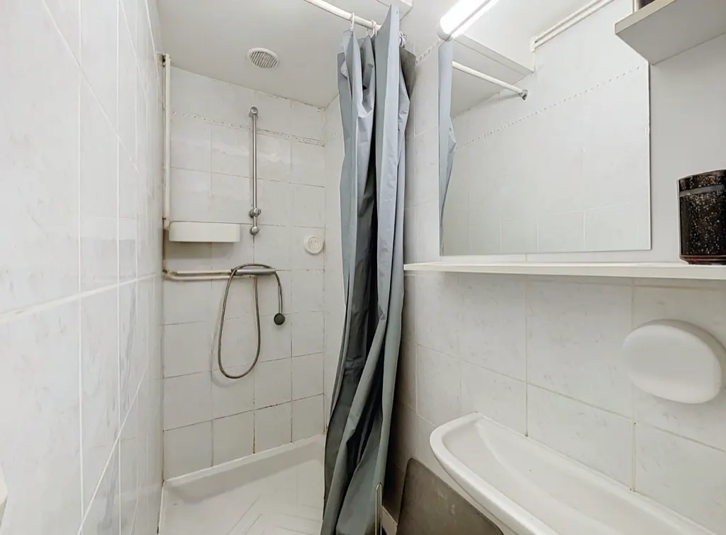 Salle d'eau carrelée de l'un des logements de l'immeuble