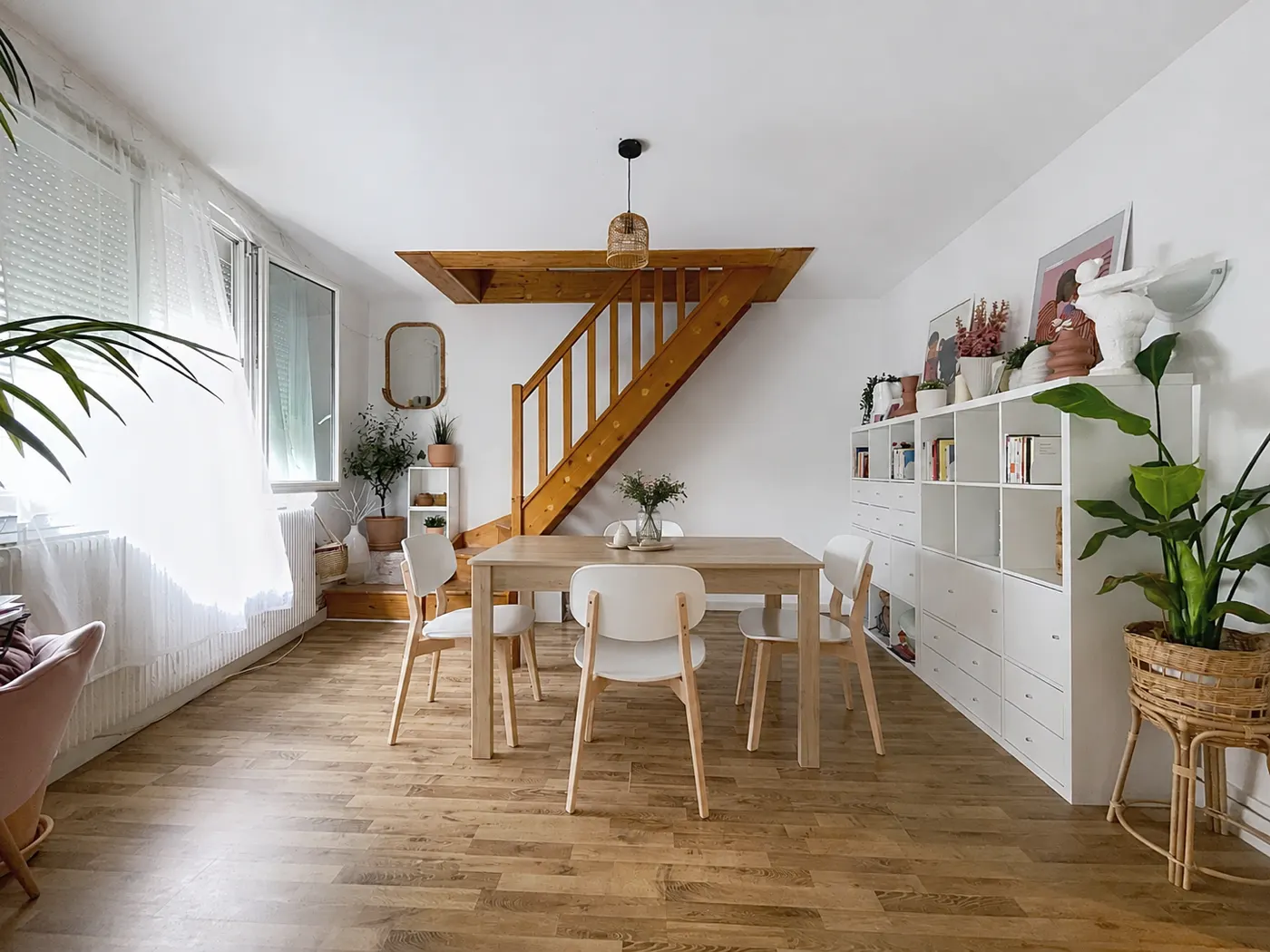 Salle à manger avec escalier en bois d'un appartement sur plusieurs niveaux