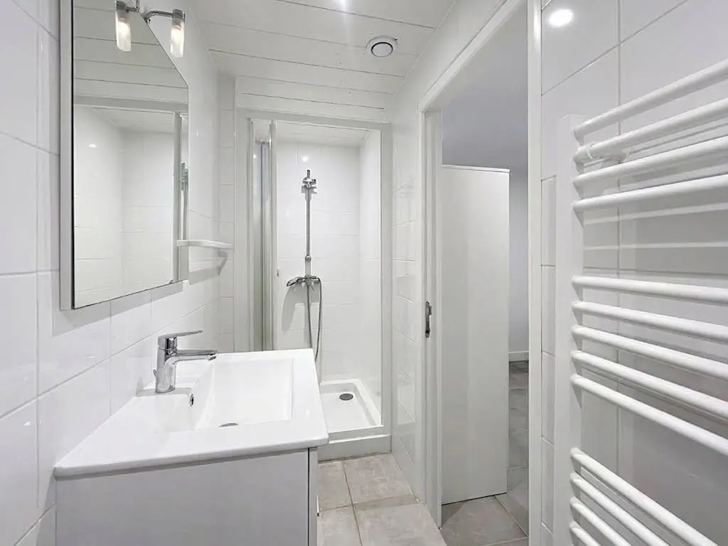 Salle d'eau moderne avec douche et sèche-serviettes